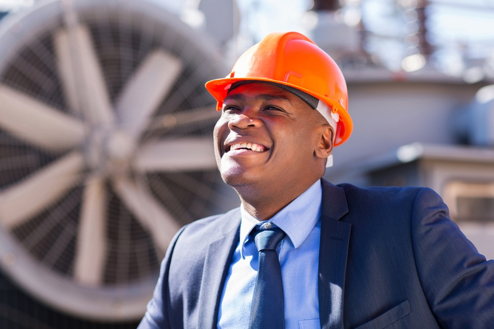 happy african american technical manager standing in electricity power plant